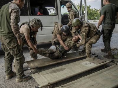 Украинские военнослужащие уносят раненого солдата после обстрела Северска. Фото: Narciso Contreras / Anadolu Agency