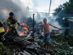 Житель Бахмута помогает пожарным тушить огонь во дворе жилого дома после обстрела/ Фото: Igor Tkachev / AFP / Scanpix / LETA